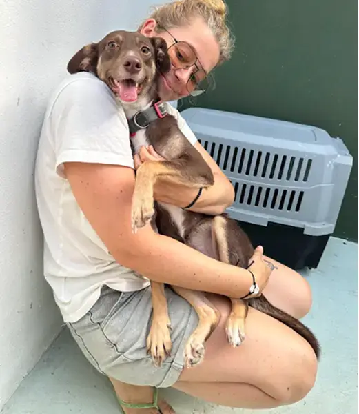 a women cuddling with a dog